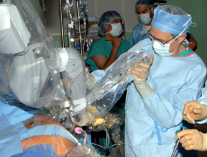 Dr. Frank C. Seifert positioning the arms of the da Vinci robot over patient about to undergo coronary bypass surgery.